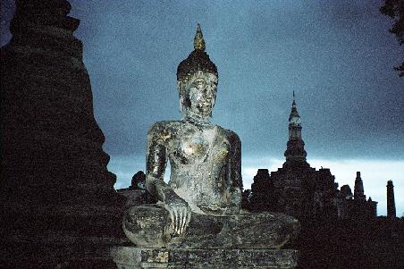 Old Sukhothai Buddha statue with storm threatening in the background