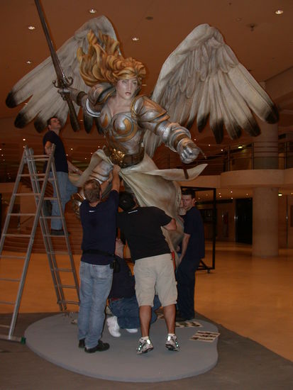 The crew assembles the huge angel statue in the lobby of the Louvre event space.