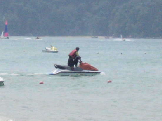 A dog is jetskiing with his owner