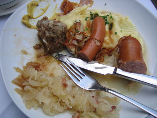 three different types of brats, sauerkrat, and liver dumpling