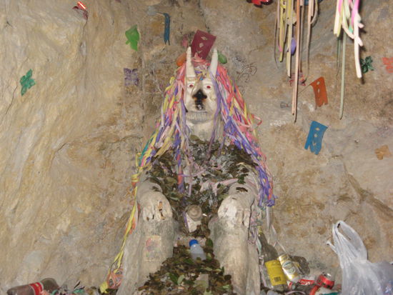 Statue of "El Tio" in a side tunnel of the mine. It symbolises the devil, to whom the miners make offerings, like coca leaves but also drinks. The miners say: "God may rule above the ground, but El Tio does below".