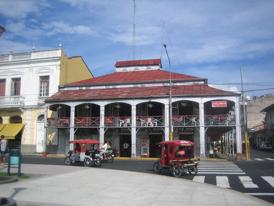 The Eiffel-house in Iquitos with two taxis in the front.