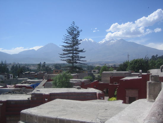 View from the roof tops of Santa Catalina. All the red houses in the front belong to the cloyster; one of the three vulcanos of Arequipa in the back.