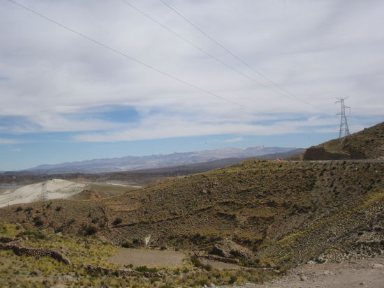 A green hill in a dessert-like environment.