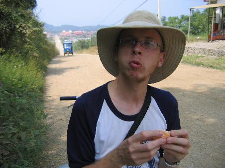 Me eating an orange. Catherine says i eat like i monkey. Do i eat like a monkey? Note the tuk-tuk coming to run us down.